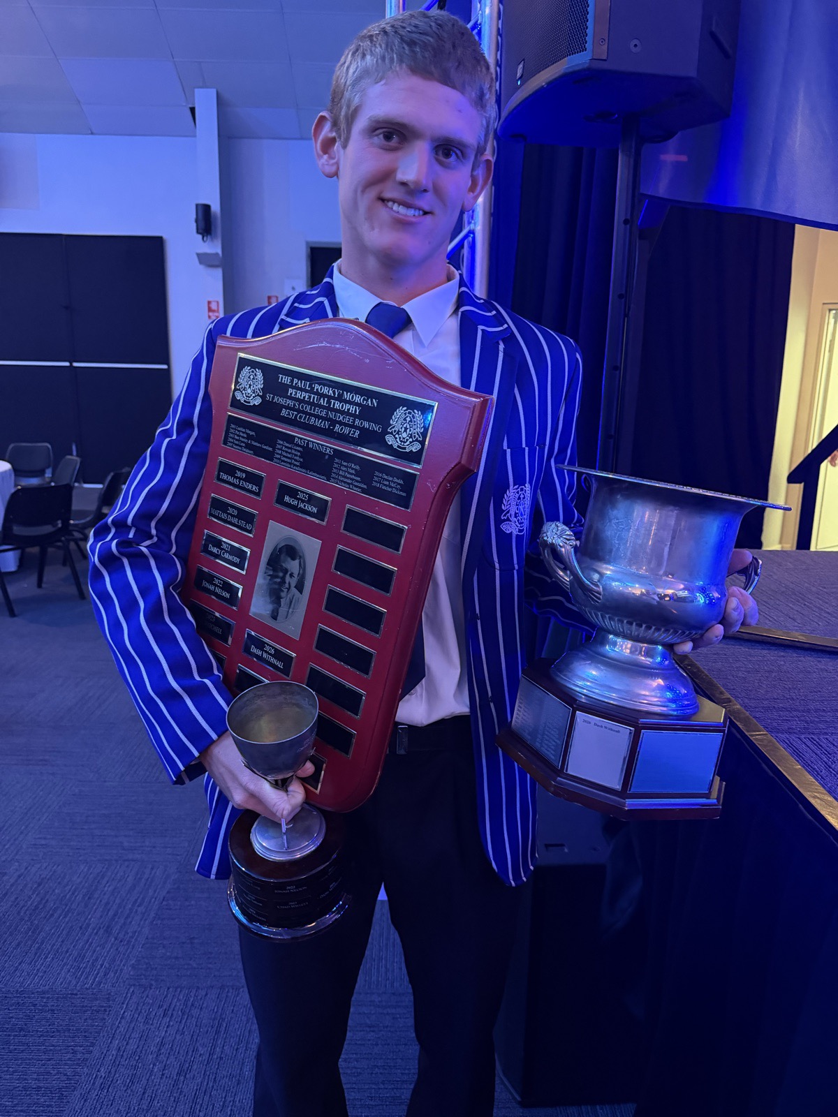 Dash Withnall holding the Paul Morgan Perpetual Trophy and rowing cups